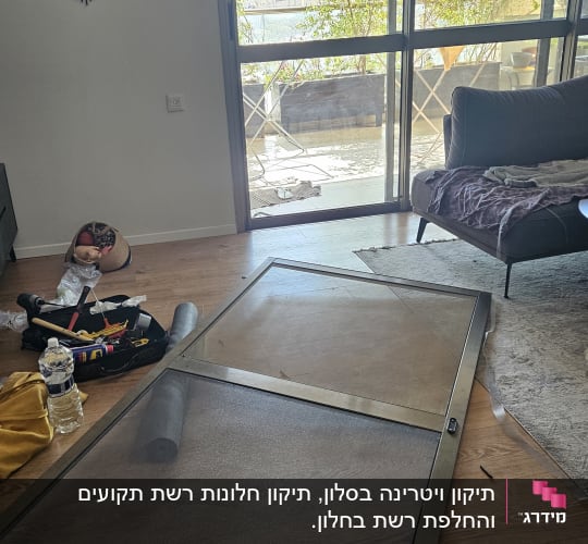 מסגרת חלון על הרצפה ליד כלים וחלון זכוכית